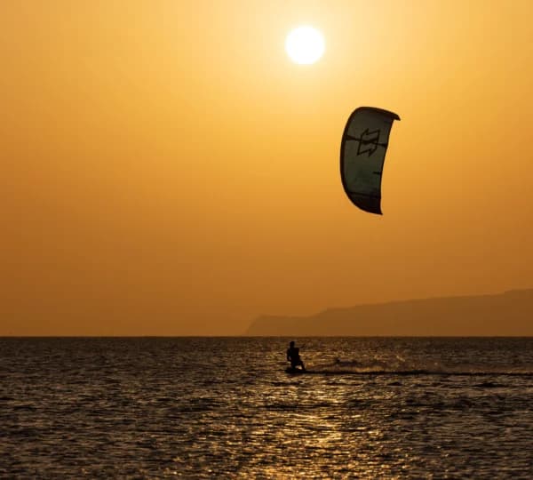 Kitesurfer riding across flat turquoise water off Hurghada on the Red Sea